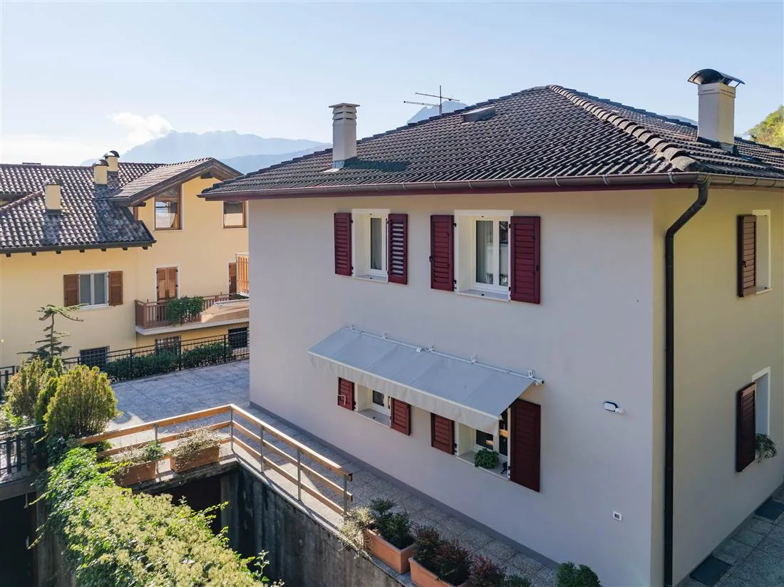 La villetta vista dall'alto, con la tenda da sole, il cortile e le montagne sullo sfondo