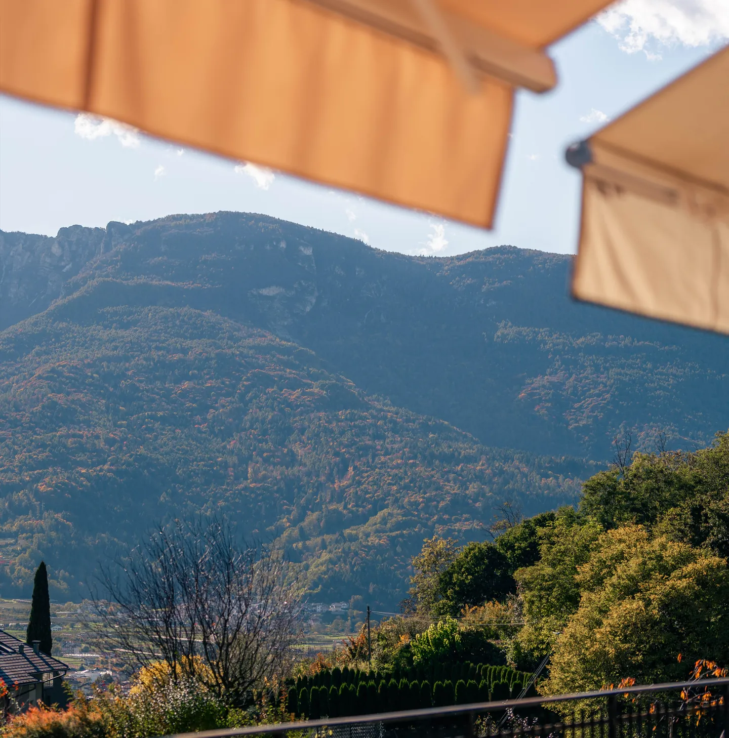 La terrazza di Symphony Home: le tende da sole, il giardino e le montagne della Valsugana